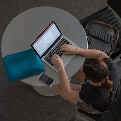 student on laptop at round table 